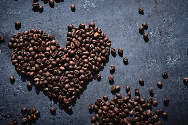 Roasted coffee beans in the shape of a heart on a gray background love coffee