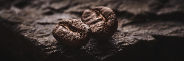 石の台座の茶色の背景にコーヒー豆の焙煎