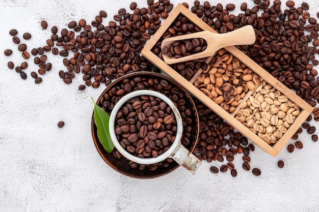 Roasted coffee beans with scoops setup on white concrete background