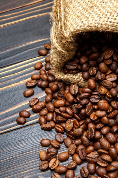 Chicchi di caffè arrostiti su fondo di legno