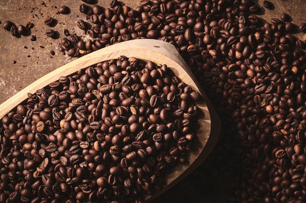 Roasted coffee beans in wooden bowl brown background