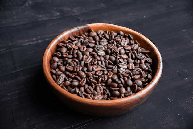 Roasted coffee beans in wooden bowl.