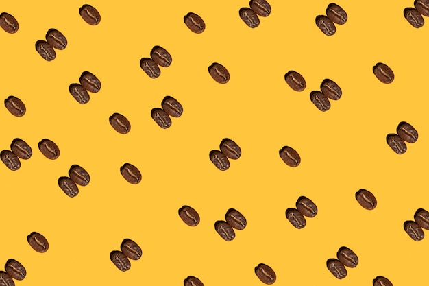 Roasted coffee beans on yellow background pattern