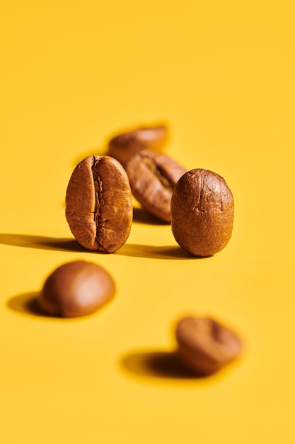 Roasted coffee beans on yellow background