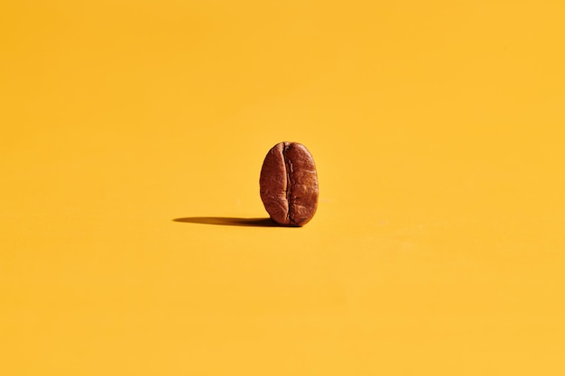 Roasted coffee beans on yellow background