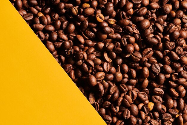 Roasted coffee beans on yellow background