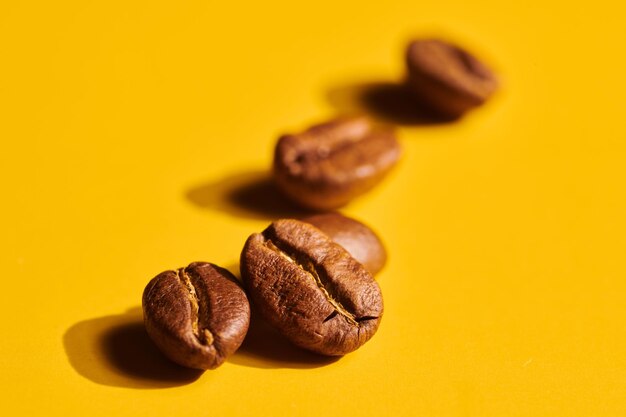 Roasted coffee beans on yellow background