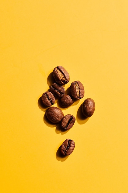 Roasted coffee beans on yellow background