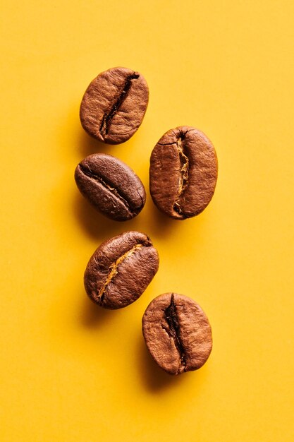 Roasted coffee beans on yellow background