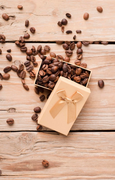 roasted coffee beans in yellow gift box with bow on wooden table