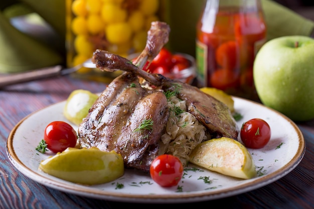 Roasted Duck leg with garnish on a plate.