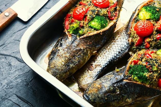 Roasted fish stuffed with broccoli and quinoa.Baked fish with vegetables in tray