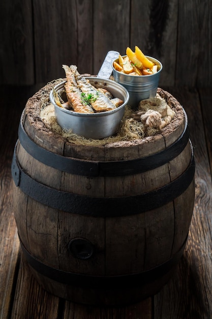Roasted herring fish with salt and herbs on old barrel