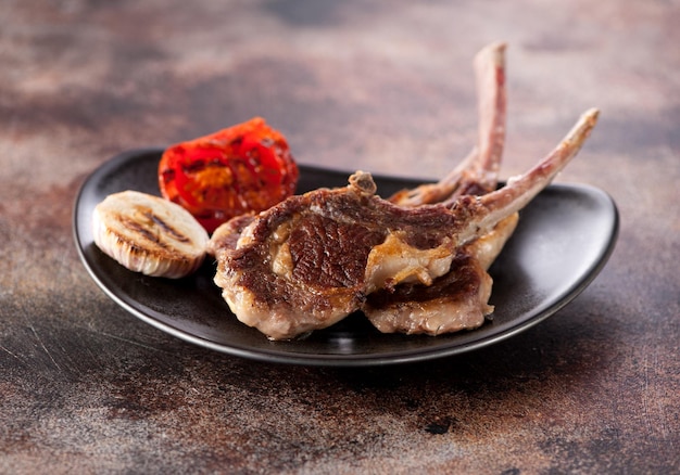 Roasted lamb cutlets ribs with garlic and tomato