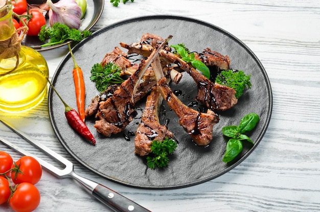 Roasted lamb ribs with spices and garlic on a dark kitchen table Rustic style Photo for the catalog