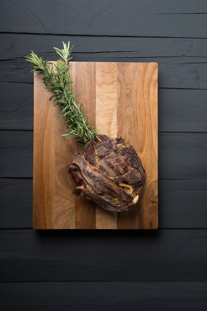 Roasted meat on a black wooden background