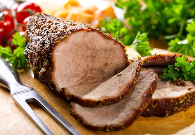 Roasted meat with vegetables on wooden board