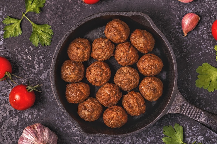 Photo roasted  meatballs with tomatoes, garlic and parsley