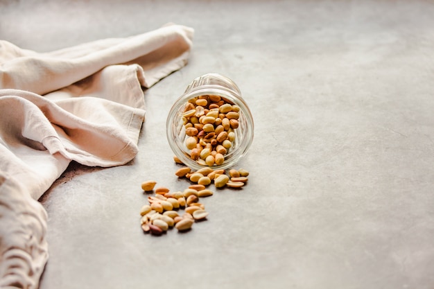 Roasted peanuts in a glass on gray 