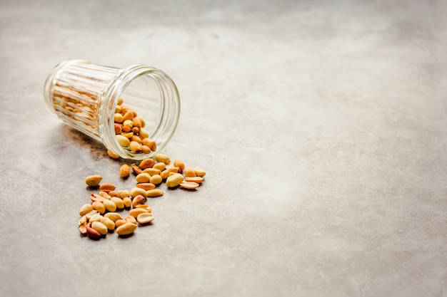 Roasted peanuts in a glass on gray