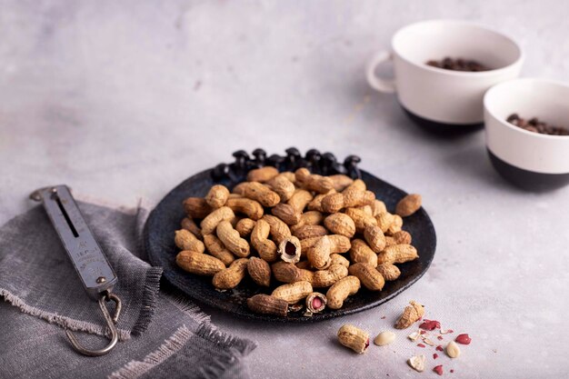 Roasted peanuts in a gray bowl on a gray background