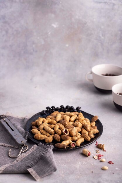 Roasted peanuts in a gray bowl on a gray background