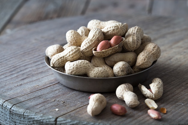 Roasted peanuts with peanut shells on wooden  