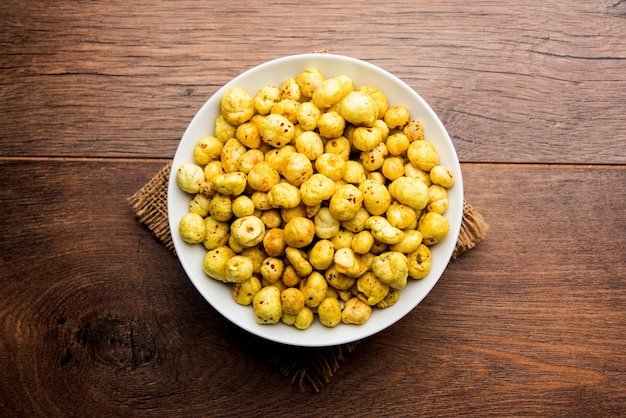 Photo roasted phool makhana or crispy lotus pops seed served in a bowl, selective focus