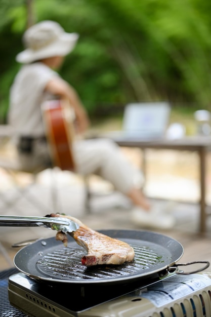 Una bistecca di braciola di maiale arrosto sulla padella da picnic calda da campeggio attività all'aperto e campeggio
