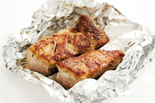 Photo roasted pork filet in aluminum foil