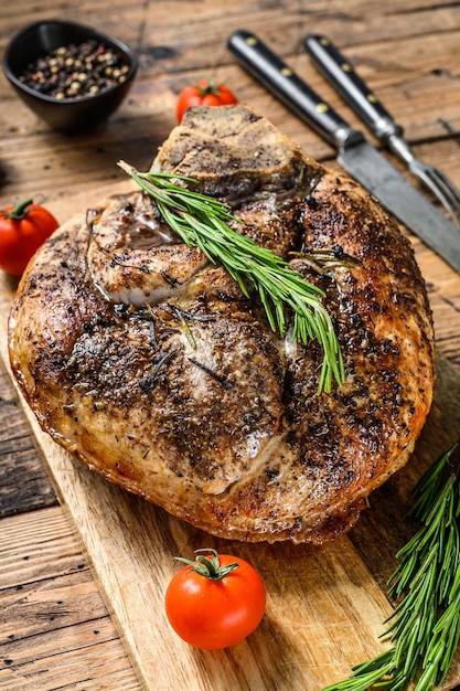 Roasted pork ham on a cutting board.  Shank meat.