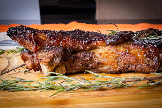 Roasted pork ribs with rosemary barbecue sauce on a wooden board place for text