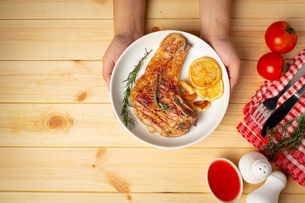 Roasted pork steak on wooden surface.