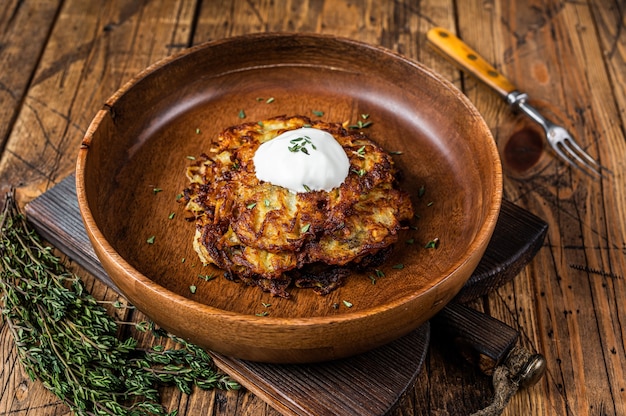 Roasted Potato pancakes or Fritters with  herbs in a wooden plate