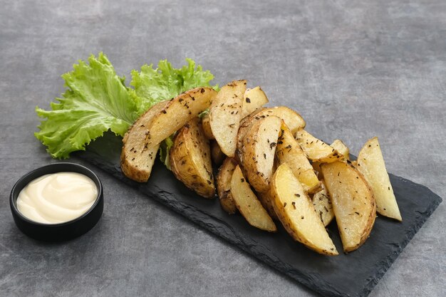 Roasted potato wedges with rosemary and herbs served with mayonnaise sauce