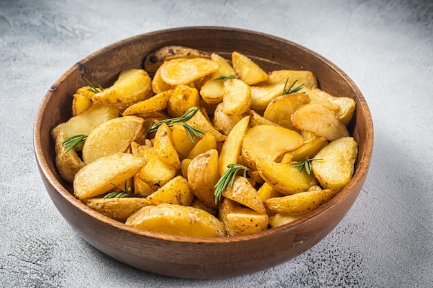 Roasted potato wedges with rosemary organic vegetarian potato wedges meal White background Top view