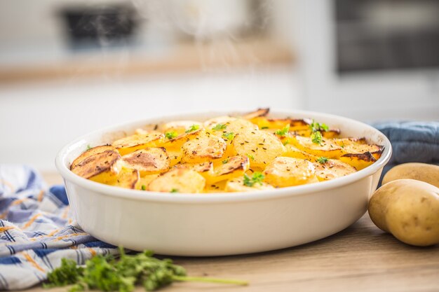 Roasted potatoes with spices and herbs on kitchen table.