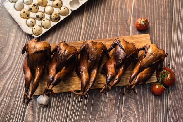 Roasted quails on a wooden board. Rural concept.