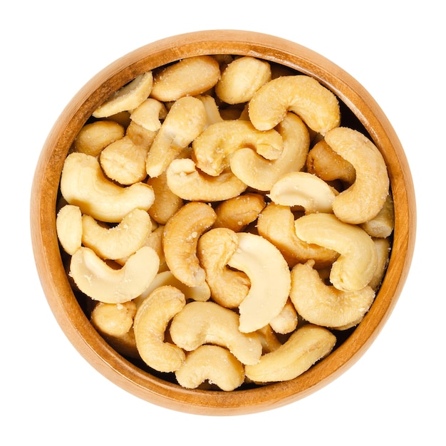 Roasted and salted cashews in wooden bowl