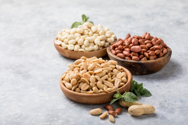 Roasted salted peanuts. Crispy nuts in bowl on stone table.