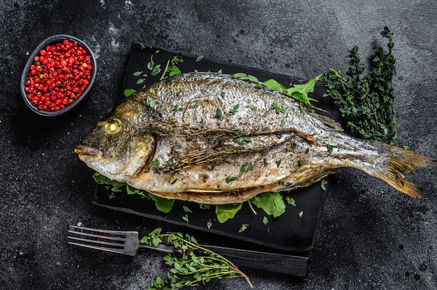 Roasted sea bream  fish with herbs on a cutting board