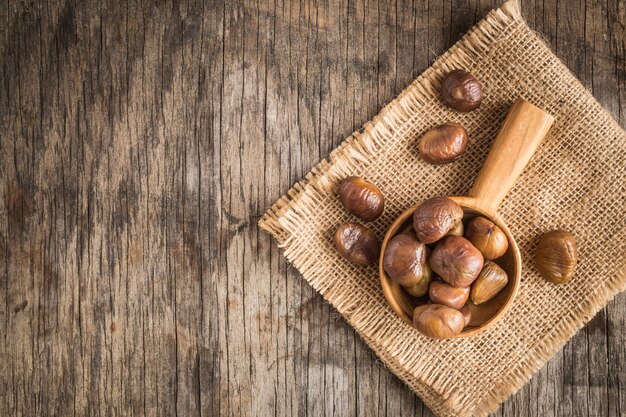 Roasted sweet chestnuts on wooden table. Top view with copy space