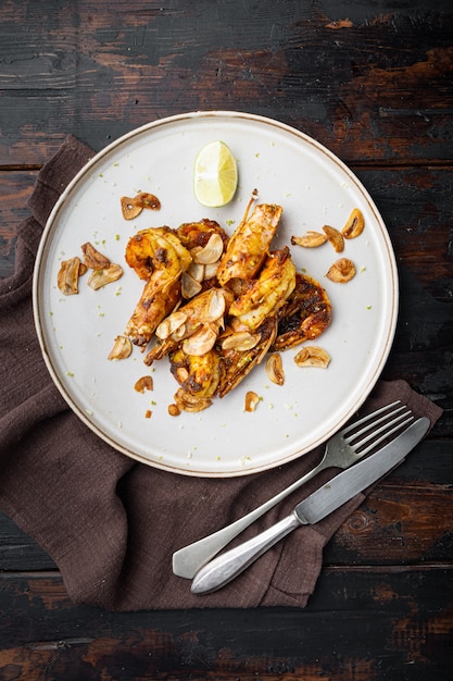 Roasted tiger prawns with Mango chutney and crispy garlic set, on plate, on old dark  wooden table