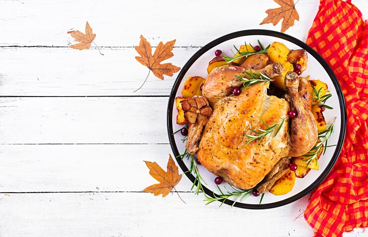 Photo roasted turkey garnished with cranberries on a rustic style table decorated autumn leaf thanksgiving day baked chicken top view