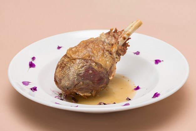 Roasted turkey leg, served with white sauce, decorated with herbs