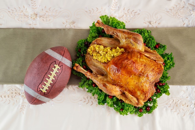 Roasted turkey with football ball. Thanksgiving football concept.