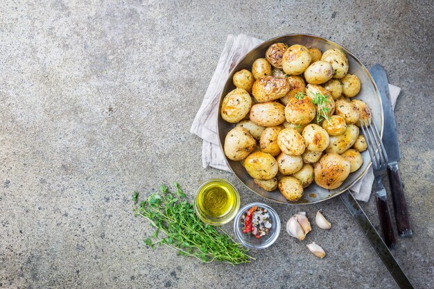 Roasted whole baby potatoes with greens and garlic oil over gray stone