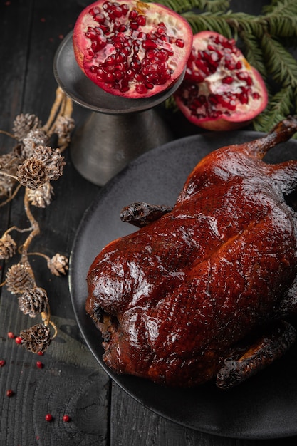 Roasted whole Peking Duck on dark table