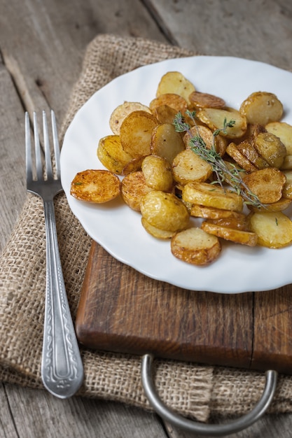 Foto giovani patate arrostite con timo in piatto bianco