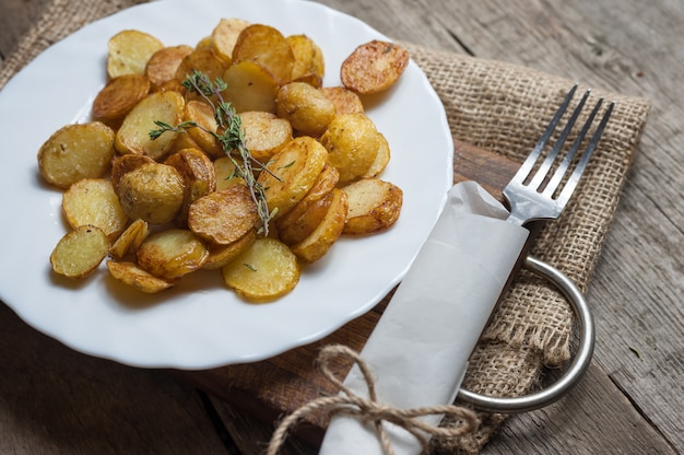 Roasted young potatoes with thyme in white plate